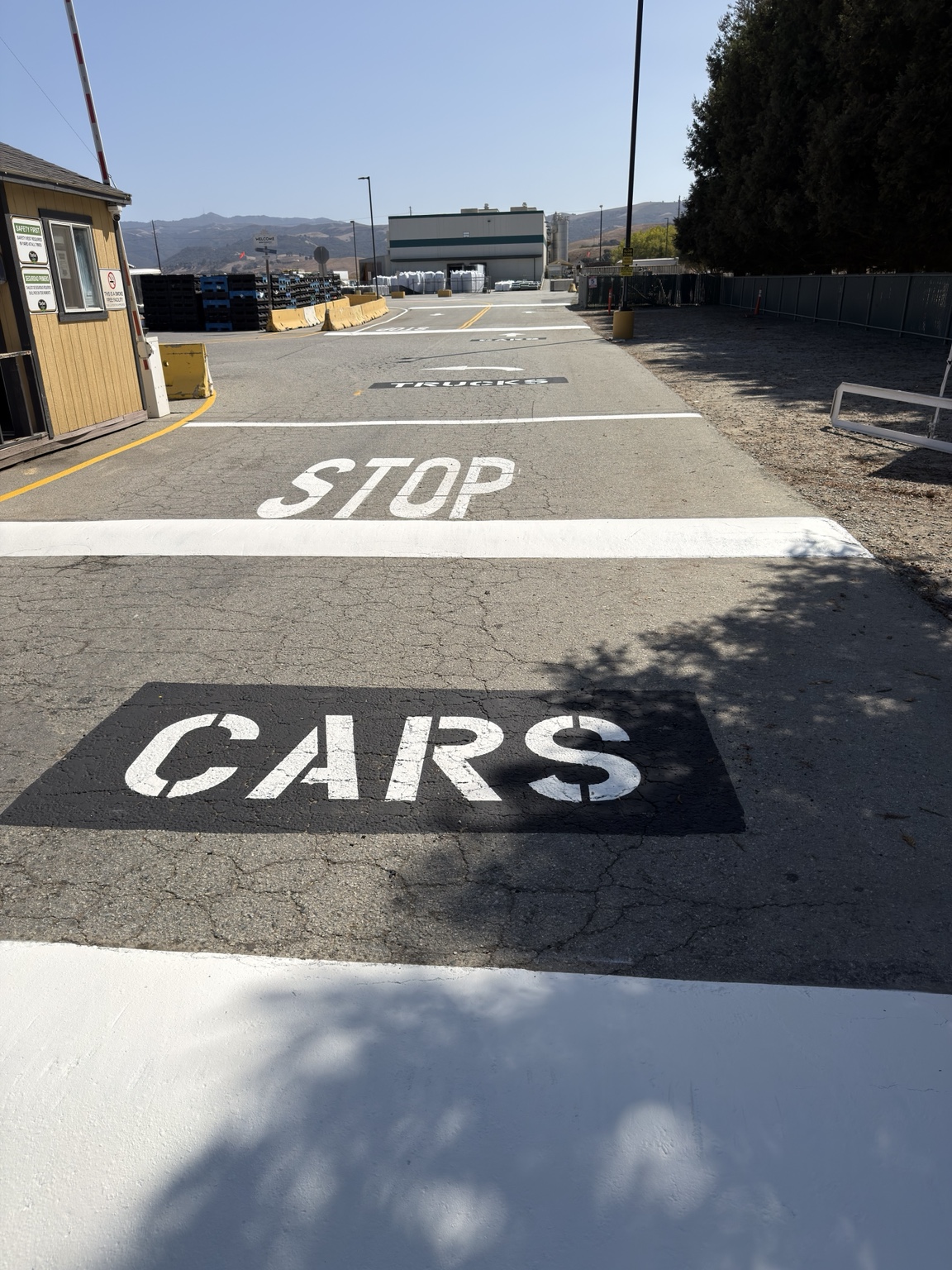 Site entrance with CARS and TRUCKS stencils separating two lanes