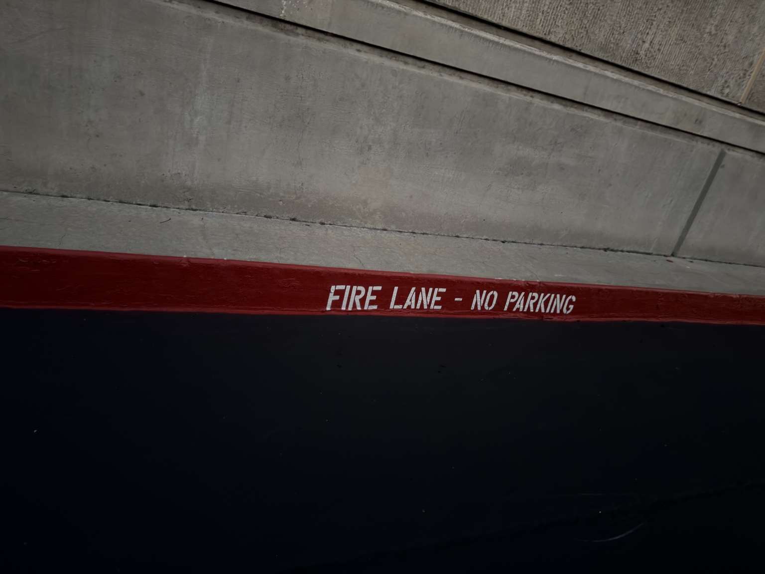 FIRE LANE – NO PARKING lettering on a freshly painted red curb
