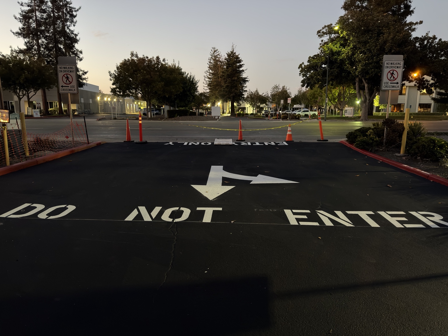DO NOT ENTER stencil with a directional arrow on fresh asphalt
